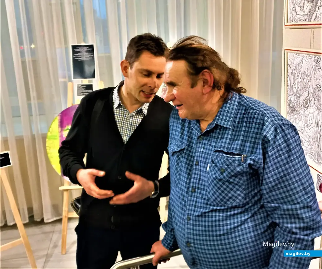 Виктор Буга (справа) возле своих выставочных графических листов. Могилев, 2023 год.