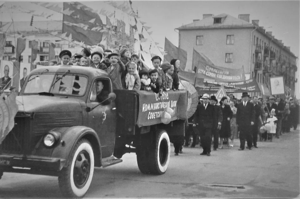 1962 год. На параде. Женя стоит на машине, на что-то указывает, вытянув руку.