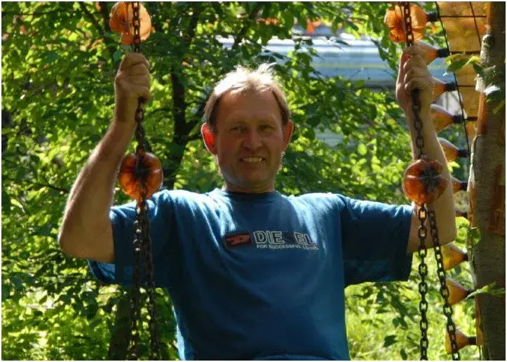 Евгений Джон Корнеев на качелях в саду своего уже снесенного «бутылочного» домика на Подниколье