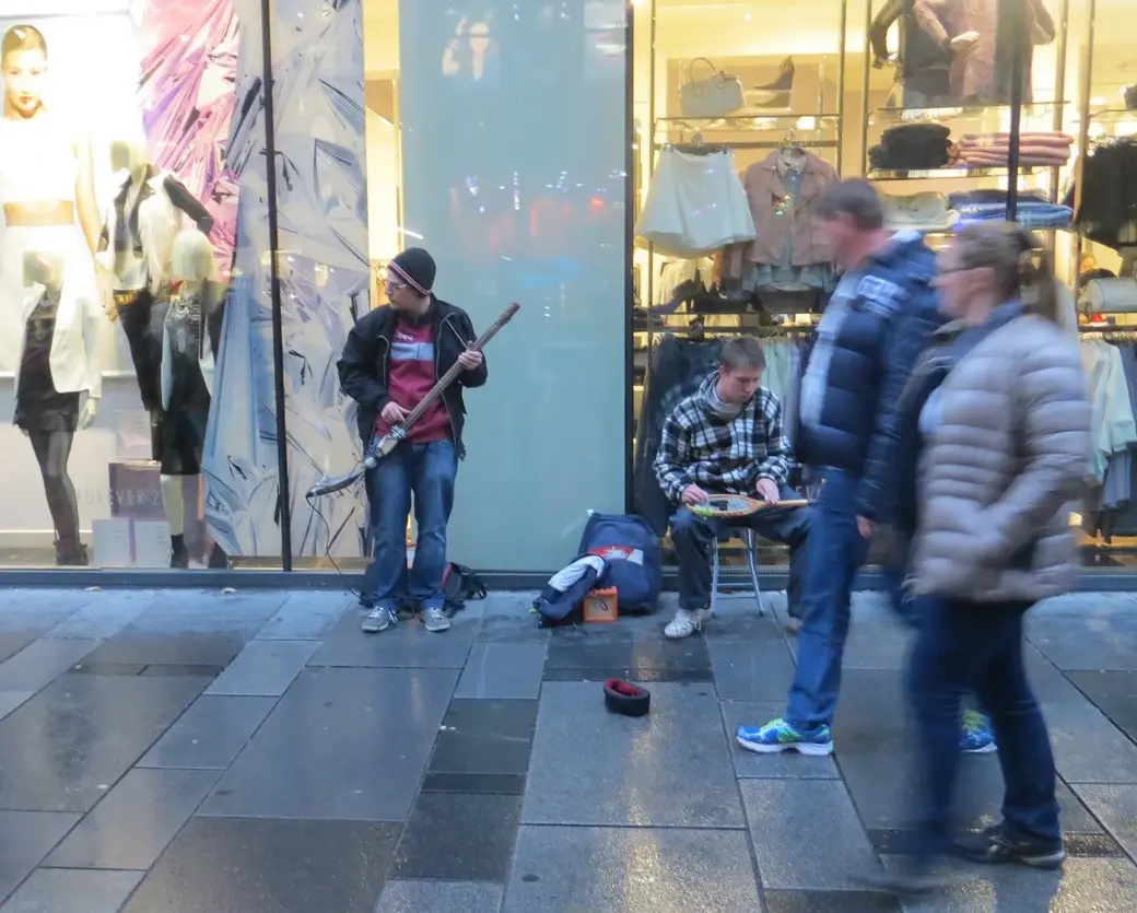Уличные музыканты: один играет на лопате, второй - на ракетке для бадминтона. Фото 2015 года