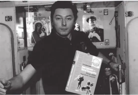 Космонавт Сергей Ревин с книгой Сола Шульмана на борту корабля.