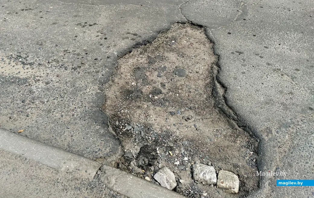 Засыпаны кирпичом не все ямы на дорогах во дворы проспекта Шмидта. Могилев, 10 июня, 2022 года.