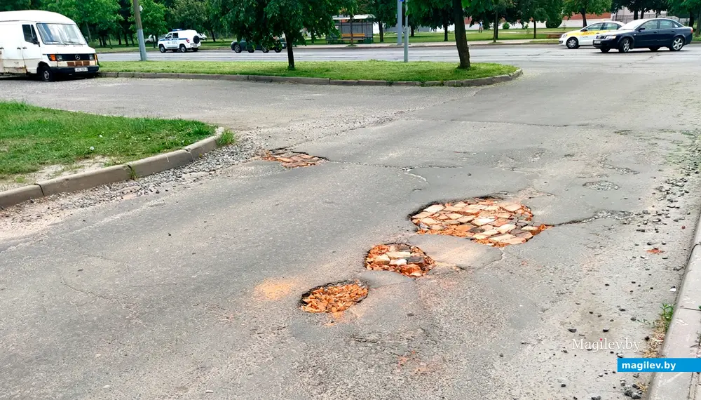 Яма на дороге во дворы проспекта Шмидта. Могилев, 10 июня, 2022 года.