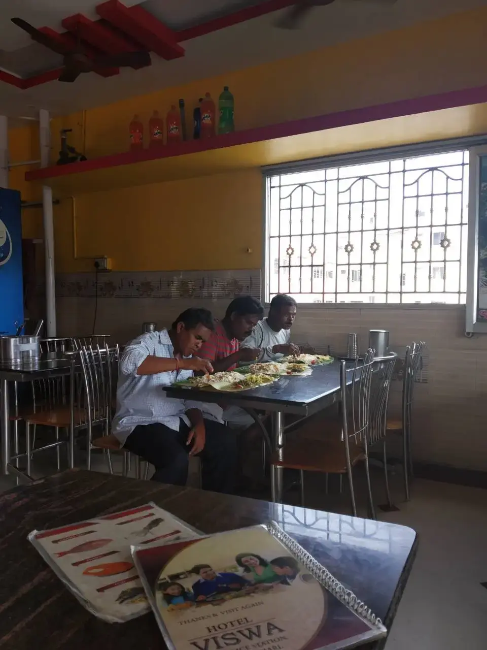 Индийцы едят на банановых листья в столовой.