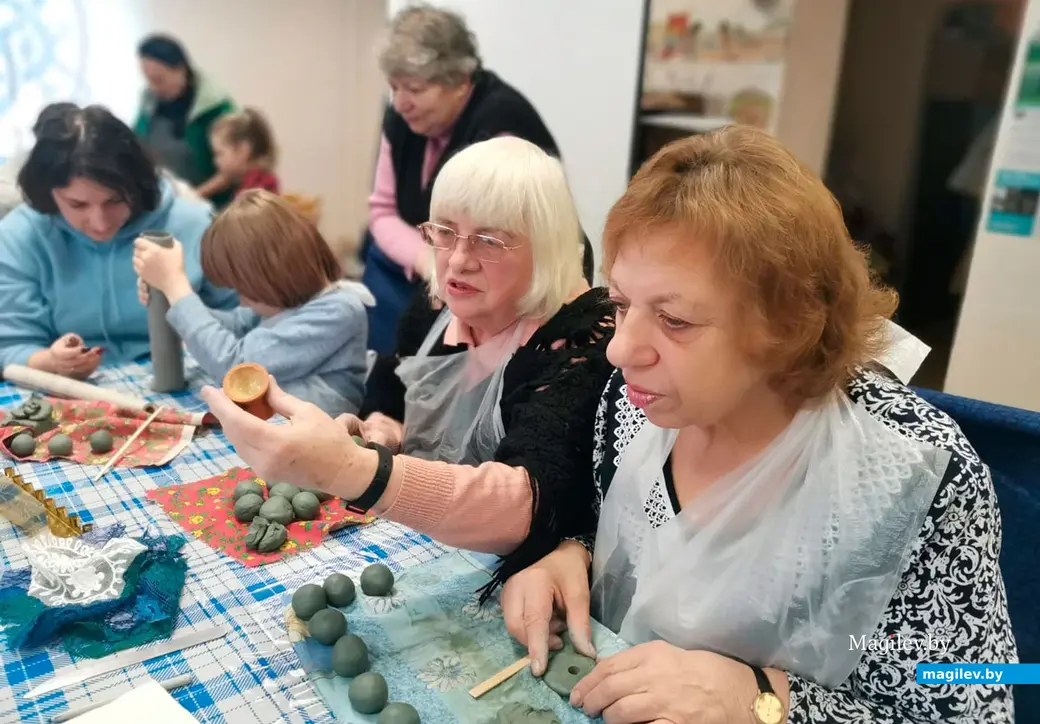 Члены Могилевской еврейской общины с детьми, внуками и правнуками делают традиционный еврейский подсвечник с 9 рожками для свечей Хануки. Могилев, декабрь 2022 год.