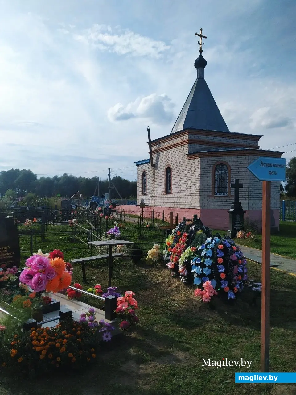 Кладбище с указателем теста, где находятся растущие каменные кресты.