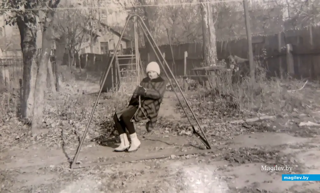 1980-е гг. Могилев, Пионерская, 31. Елена Сергеева во дворе родного дома на качелях.