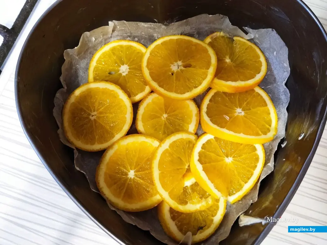 Выложить апельсиновые дольки на дно формы