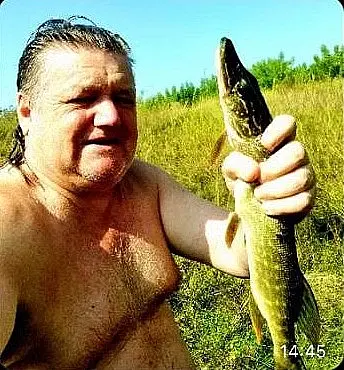 Сентябрь 2025 года, Могилев. Валера Козлов с пойманной на Гребеневском озере щукой.