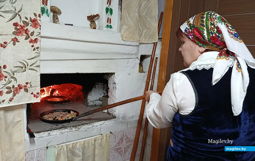 Снежань 2025 г. Галіна Васільеўна Гембіцкая гатуе бліны ў печы. Да бліноў - смажаніна.