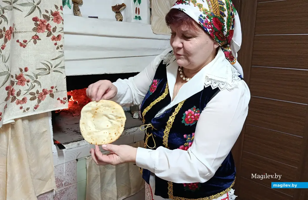 Снежань 2025 г. Галіна Васільеўна Гембіцкая гатуе бліны ў печы.