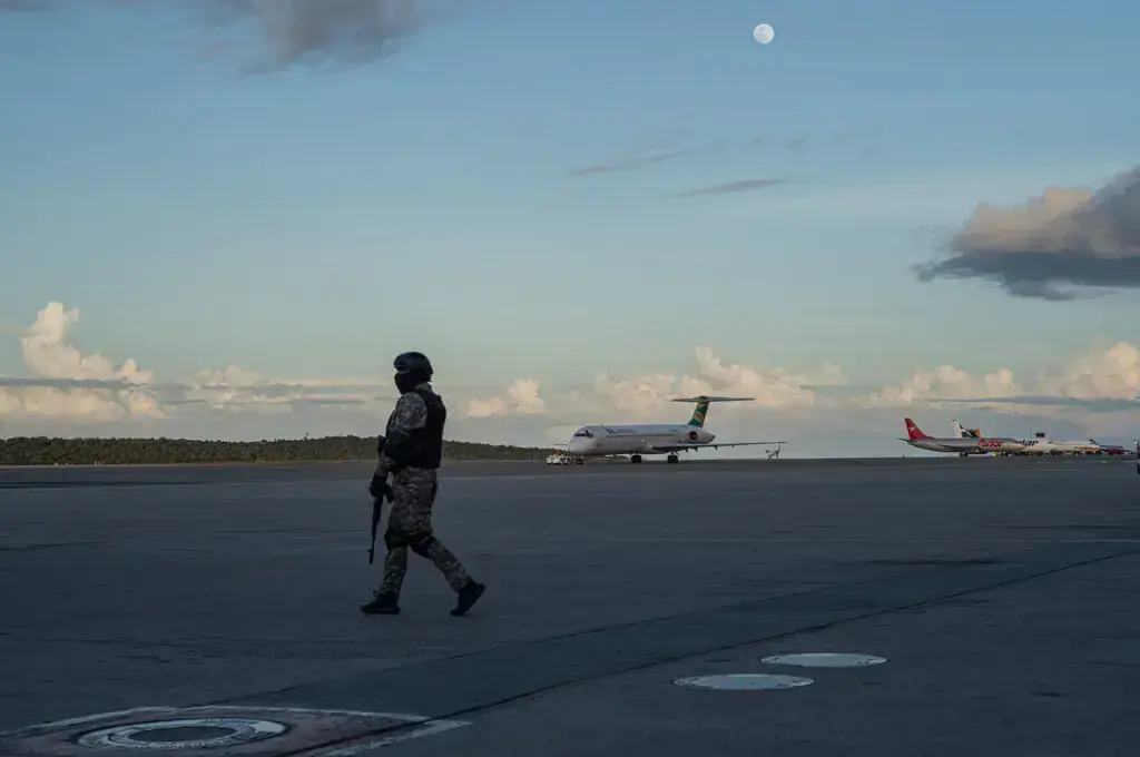 Сотрудник сил безопасности Венесуэлы на взлетно-посадочной полосе международного аэропорта имени Симона Боливара в Майкетии. Фото: The New York Times.